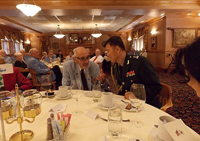 Col Weber and Major General Shin converse at main table